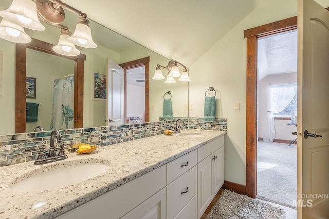 bathroom with lofted ceiling, backsplash, and vanity