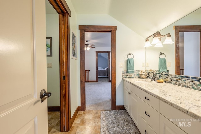 bathroom with vanity, decorative backsplash, vaulted ceiling, and ceiling fan