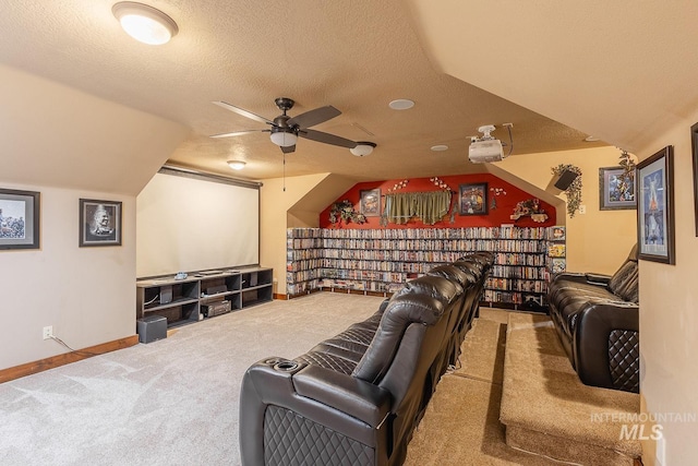 home theater room featuring ceiling fan, lofted ceiling, carpet flooring, and a textured ceiling