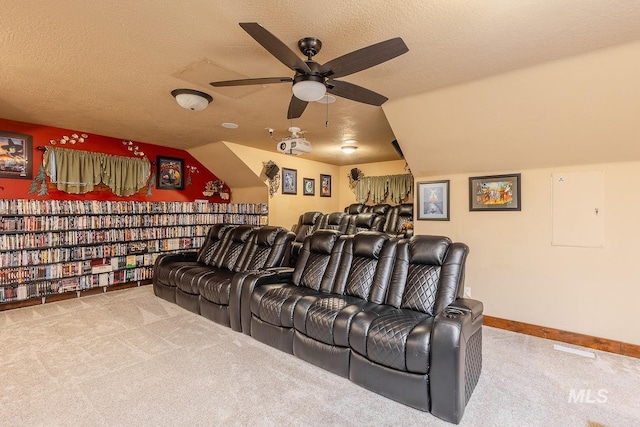 home theater with ceiling fan, carpet flooring, vaulted ceiling, and a textured ceiling