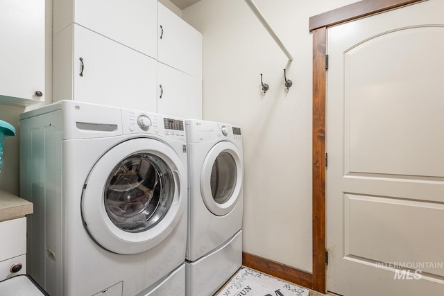 laundry area with cabinets and washing machine and clothes dryer