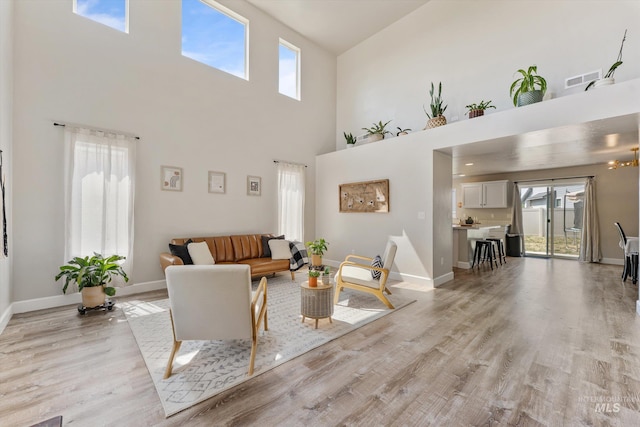 12817 Ironstone Dr, Nampa, ID 83651 - living room with healthy amount of natural light, light wood-type flooring, a towering ceiling, and baseboards