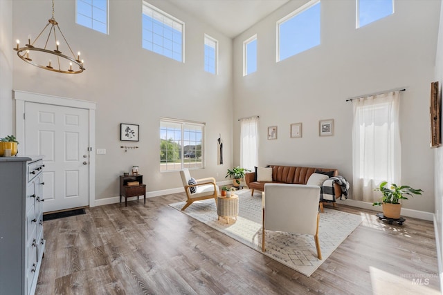 12817 Ironstone Dr, Nampa, ID 83651 - living area with a high ceiling, wood finished floors, a chandelier, and baseboards