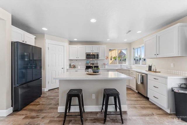 12817 Ironstone Dr, Nampa, ID 83651 - kitchen featuring appliances with stainless steel finishes, a sink, white cabinets, light countertops, and recessed lighting