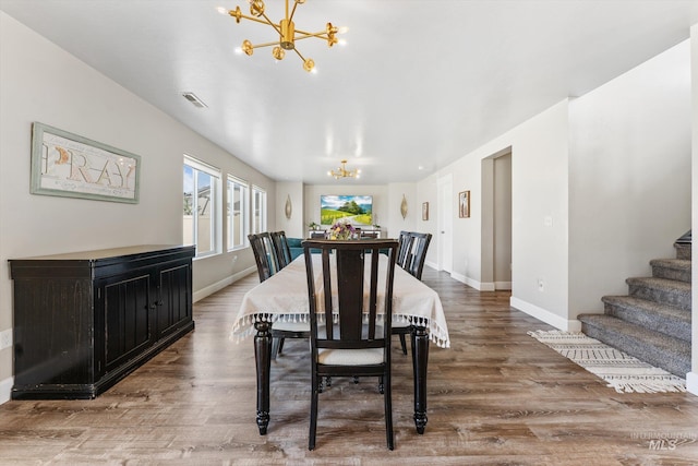 12817 Ironstone Dr, Nampa, ID 83651 - dining space with a chandelier, wood finished floors, and baseboards
