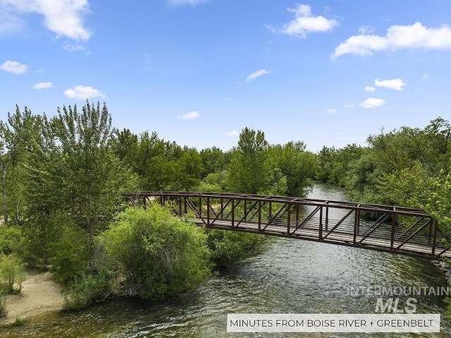 dock area featuring a wooded view and a water view