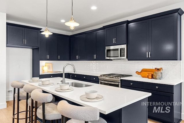 kitchen with appliances with stainless steel finishes, a sink, light countertops, backsplash, and recessed lighting