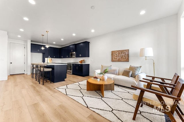 living room featuring light wood-type flooring, recessed lighting, and baseboards
