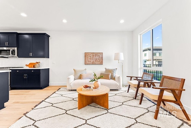 living room with light wood-style flooring, baseboards, and recessed lighting