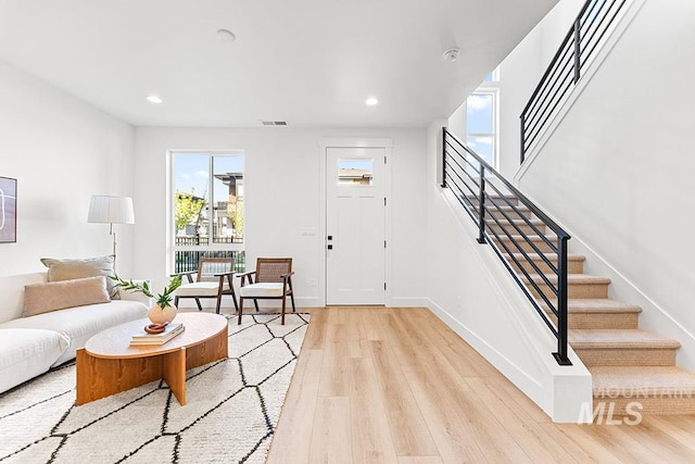 living room with stairway, light wood-type flooring, recessed lighting, and baseboards