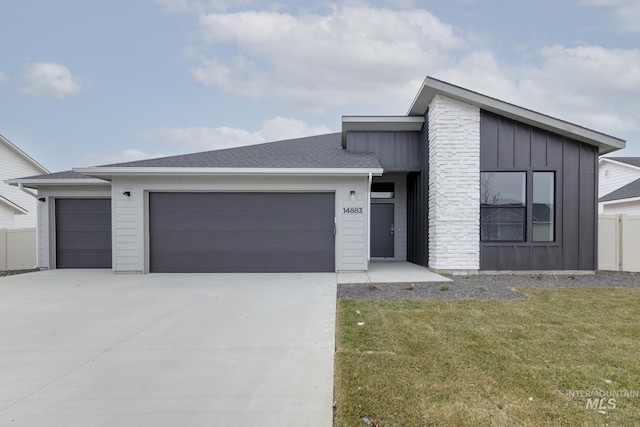 contemporary house featuring driveway, board and batten siding, a front yard, and a garage
