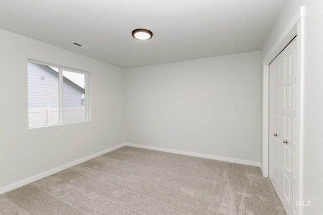 unfurnished bedroom featuring a closet, carpet flooring, visible vents, and baseboards