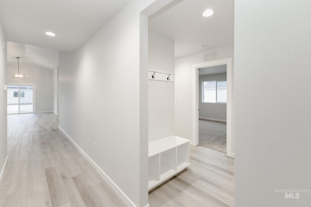 corridor featuring visible vents, light wood-style flooring, and baseboards