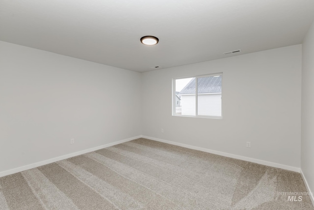 unfurnished room featuring visible vents, carpet, and baseboards