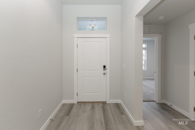 doorway to outside with visible vents, light wood finished floors, and baseboards
