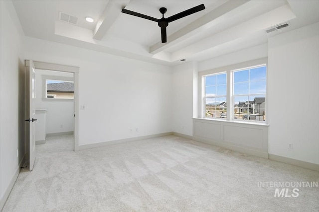 carpeted spare room with ceiling fan and a tray ceiling