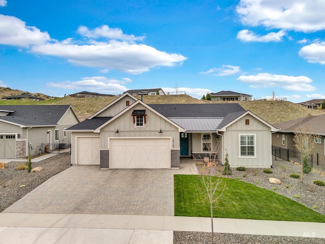 view of front of house with board and batten siding, fence, a garage, driveway, and a front lawn