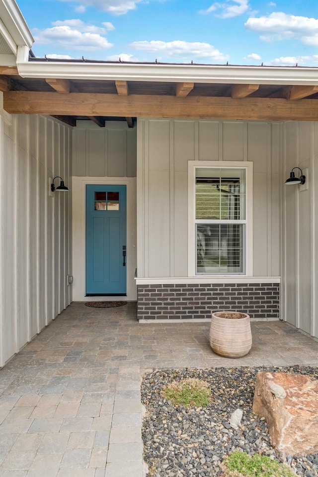 doorway to property featuring covered porch and board and batten siding