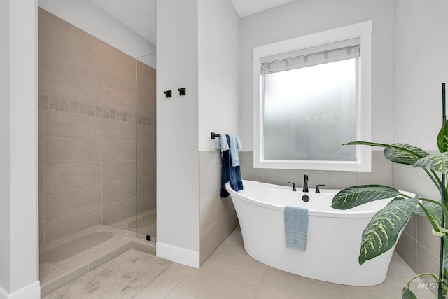 bathroom with a freestanding tub, a tile shower, and tile patterned flooring