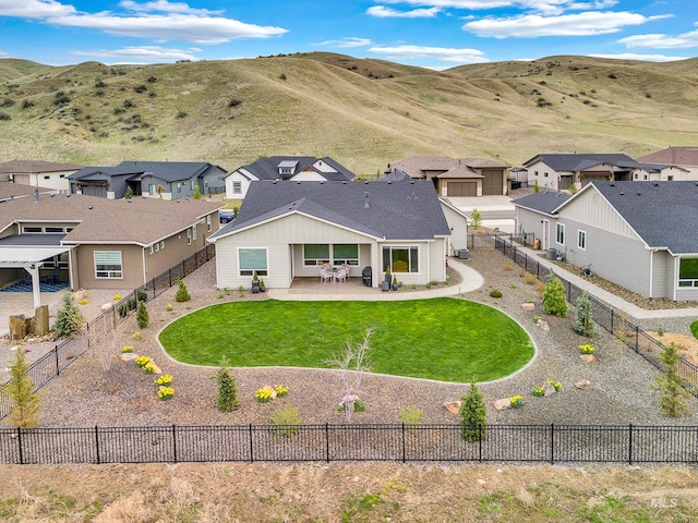 rear view of property featuring a mountain view, a patio, a residential view, and a fenced backyard