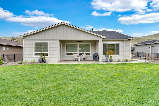 rear view of house featuring a yard, ceiling fan, a patio area, and fence