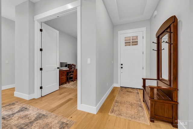 foyer entrance with light wood finished floors and baseboards