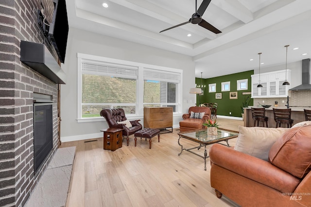 living room featuring light wood finished floors, recessed lighting, a brick fireplace, a ceiling fan, and baseboards