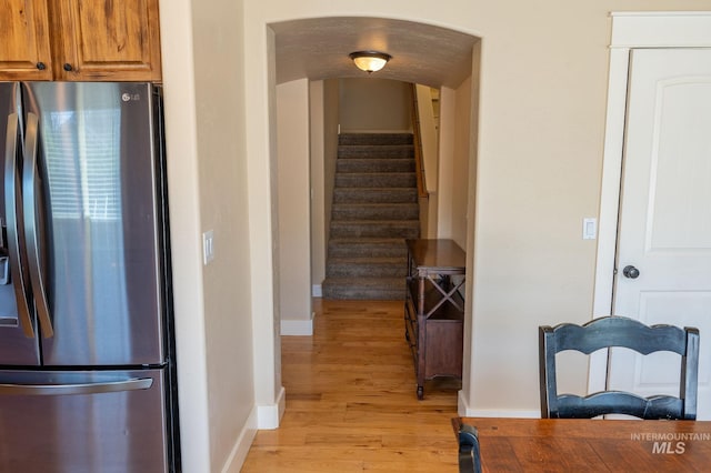 6023 S Augustine Ave, Boise, ID 83709 - kitchen with stainless steel fridge with ice dispenser, light wood finished floors, baseboards, and brown cabinets