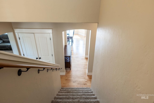 6023 S Augustine Ave, Boise, ID 83709 - stairs with wood finished floors, arched walkways, a textured wall, and baseboards
