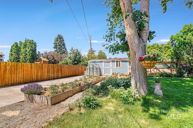 833 Nebraska, Gooding, ID 83330 - fenced backyard with a greenhouse, an outbuilding, and a garden
