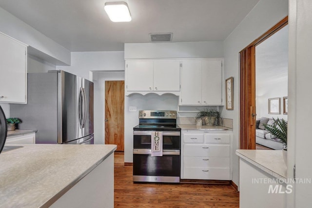 833 Nebraska, Gooding, ID 83330 - kitchen with appliances with stainless steel finishes, light countertops, dark wood-style floors, and white cabinets