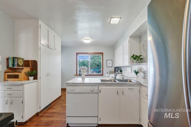 833 Nebraska, Gooding, ID 83330 - kitchen featuring freestanding refrigerator, white dishwasher, white cabinets, a peninsula, and dark wood-type flooring