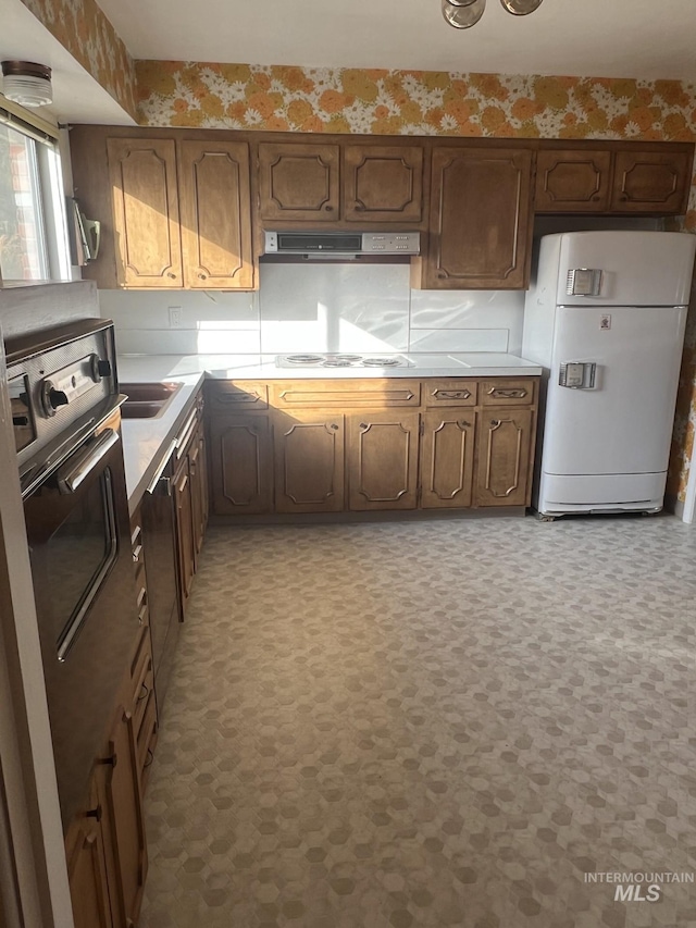 kitchen with white appliances and exhaust hood