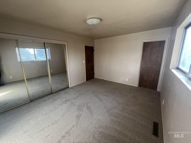 unfurnished bedroom featuring carpet and a closet