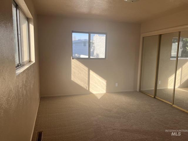 unfurnished bedroom with carpet floors and a textured ceiling