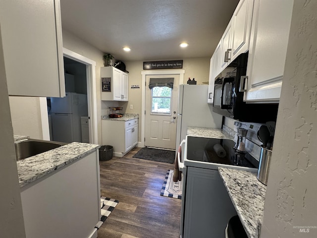 kitchen featuring white appliances, dark wood-type flooring, recessed lighting, white cabinetry, and a sink
