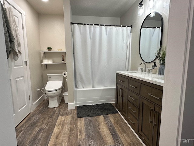 full bathroom featuring vanity, wood finished floors, toilet, baseboards, and shower / bath combo