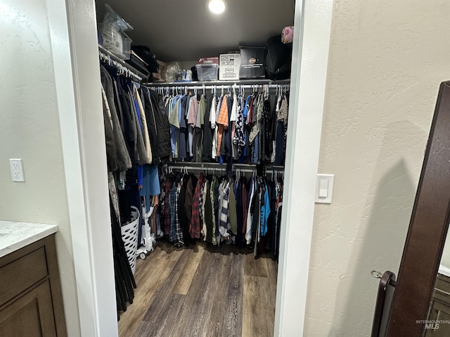 walk in closet with wood finished floors