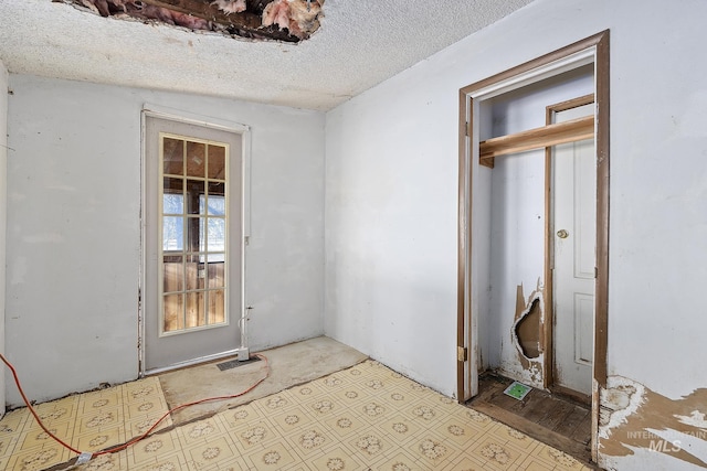 interior space with a textured ceiling and vaulted ceiling