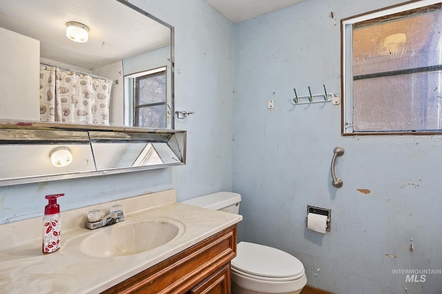 bathroom with vanity, a shower with shower curtain, and toilet