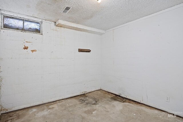 spare room with concrete floors and a textured ceiling