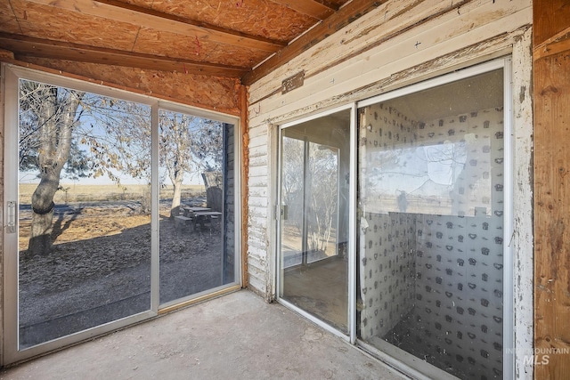 unfurnished sunroom featuring vaulted ceiling