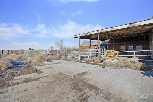 view of patio / terrace with an outbuilding and a rural view