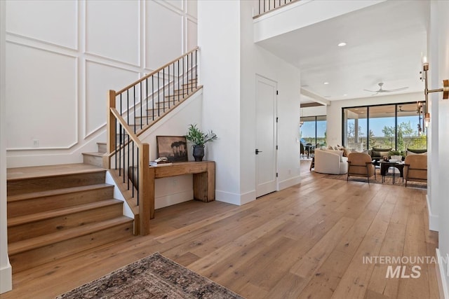 stairway with wood-type flooring, baseboards, ceiling fan, and recessed lighting