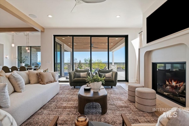 living room featuring recessed lighting, a glass covered fireplace, and ceiling fan