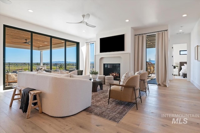 living room with ceiling fan, recessed lighting, visible vents, and light wood-type flooring