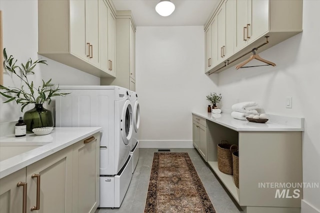 laundry area with baseboards, washer and dryer, and cabinet space