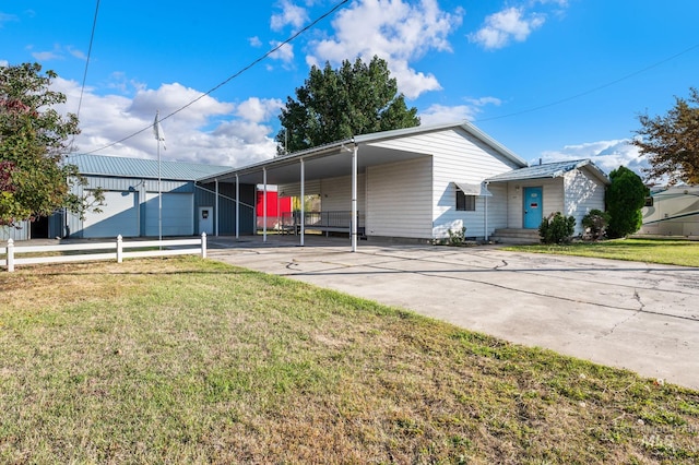 view of front of house with concrete driveway, a front lawn, and an attached carport