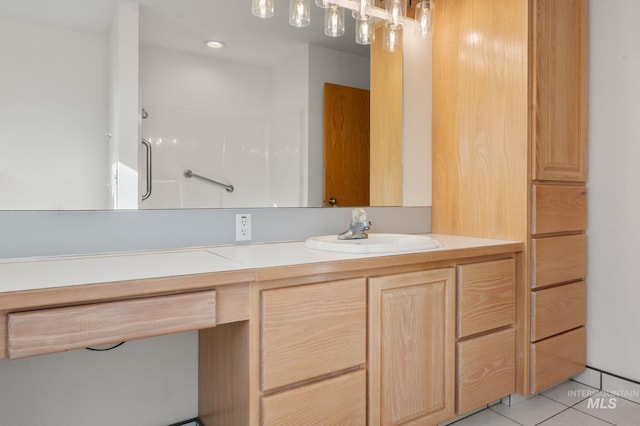 bathroom with walk in shower, vanity, and tile patterned flooring