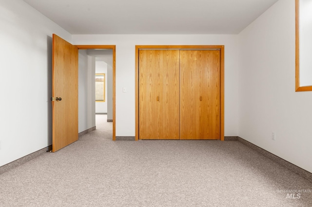 unfurnished bedroom with light carpet and a closet